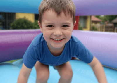Child having fun on inflatable bounce house at Giggle Party.
