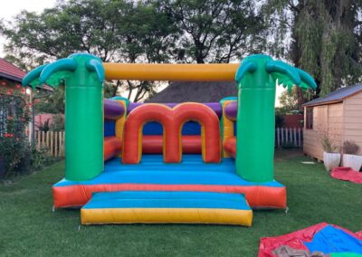 Colorful inflatable bounce house with jungle theme for children's parties.